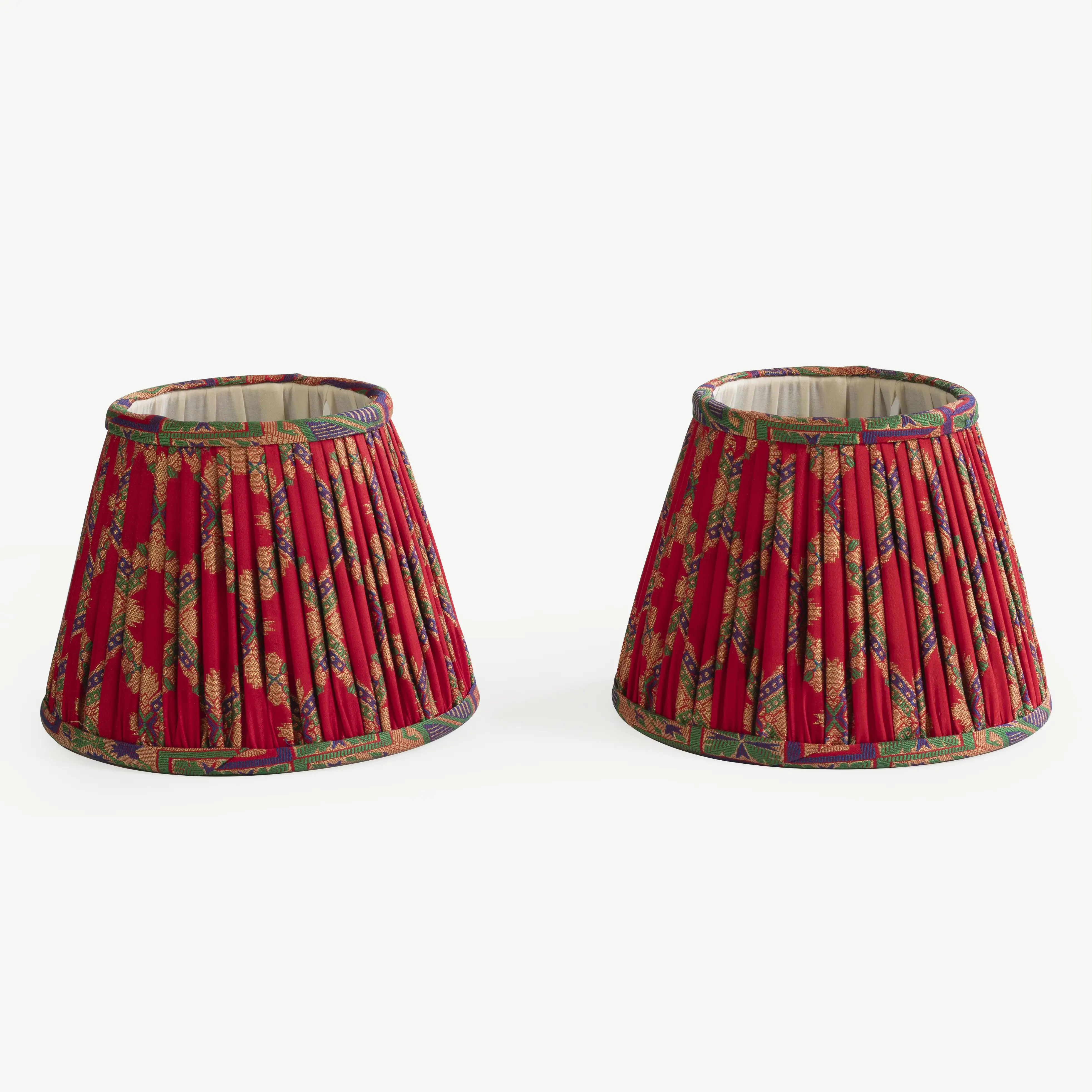 A pair of red lampshades with multicoloured detailing